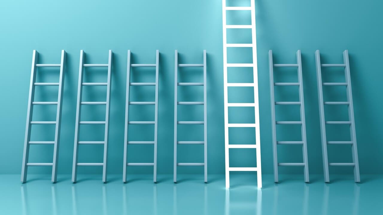 Imágenes con escaleras apoyadas sobre una pared azul, y se destaca una escalera blanca que permite escalar más arriba en las estrategias SEO